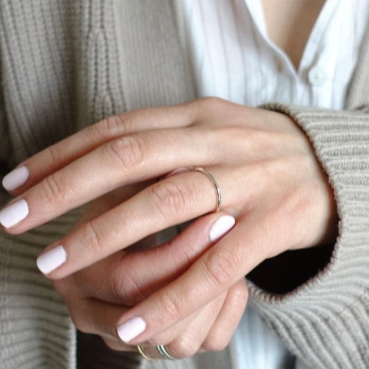 A model putting on a dainty silver Moon and Dusk stacking ring