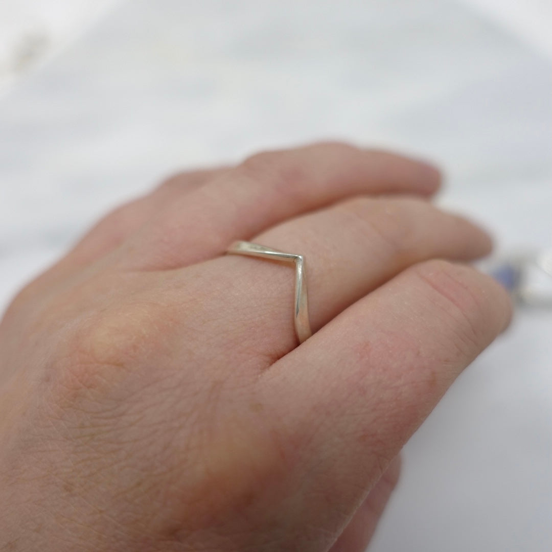 A sterling silver wishbone ring being worn
